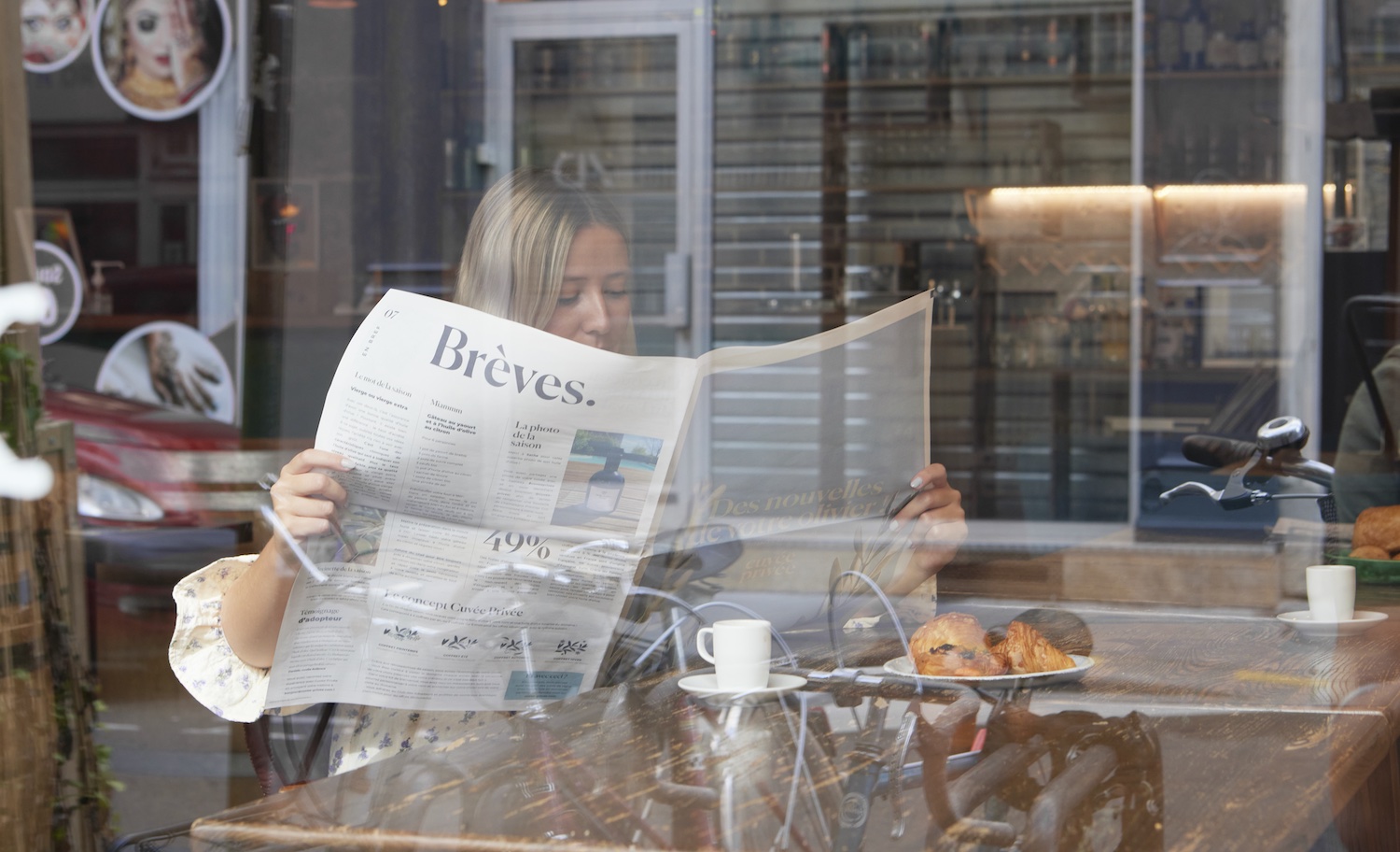 woman reading a newspaper in a cafe